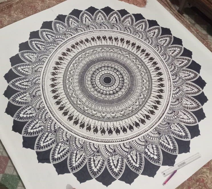 A large, symmetrical black-and-white mandala built from dense, meticulous fine-line ink patterning.